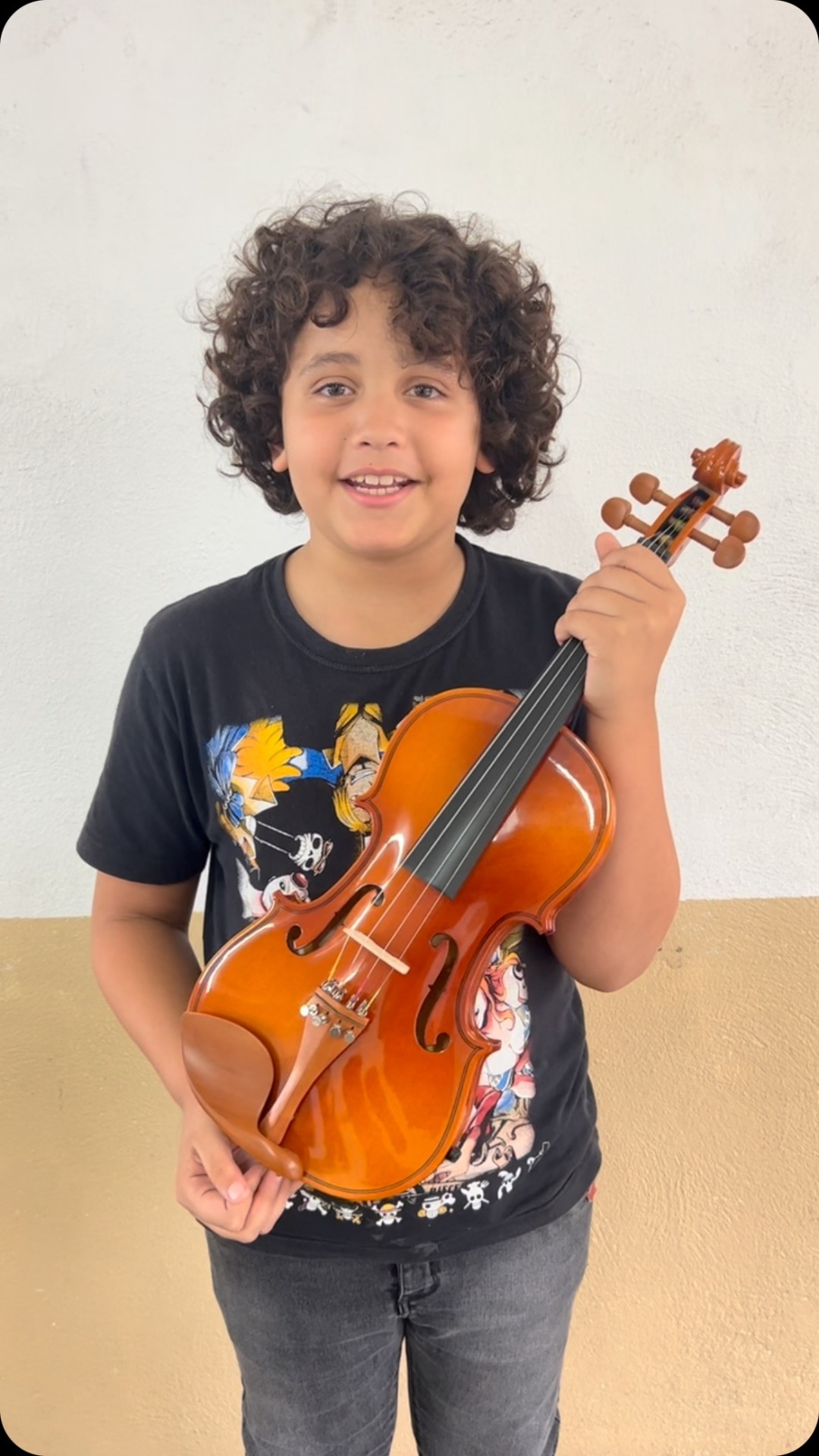 Aluno da Orquestra Mirim segurando seu violino